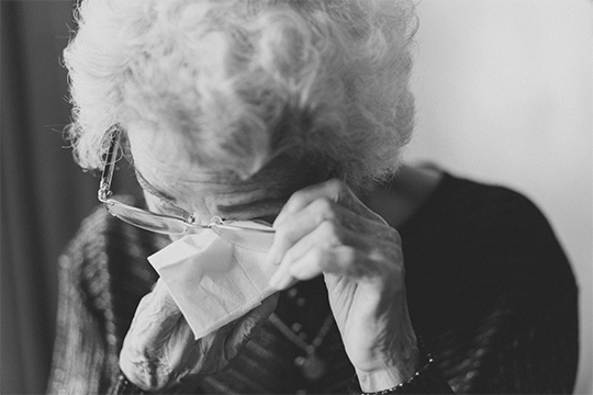 black and white photo of an elderly woman crying